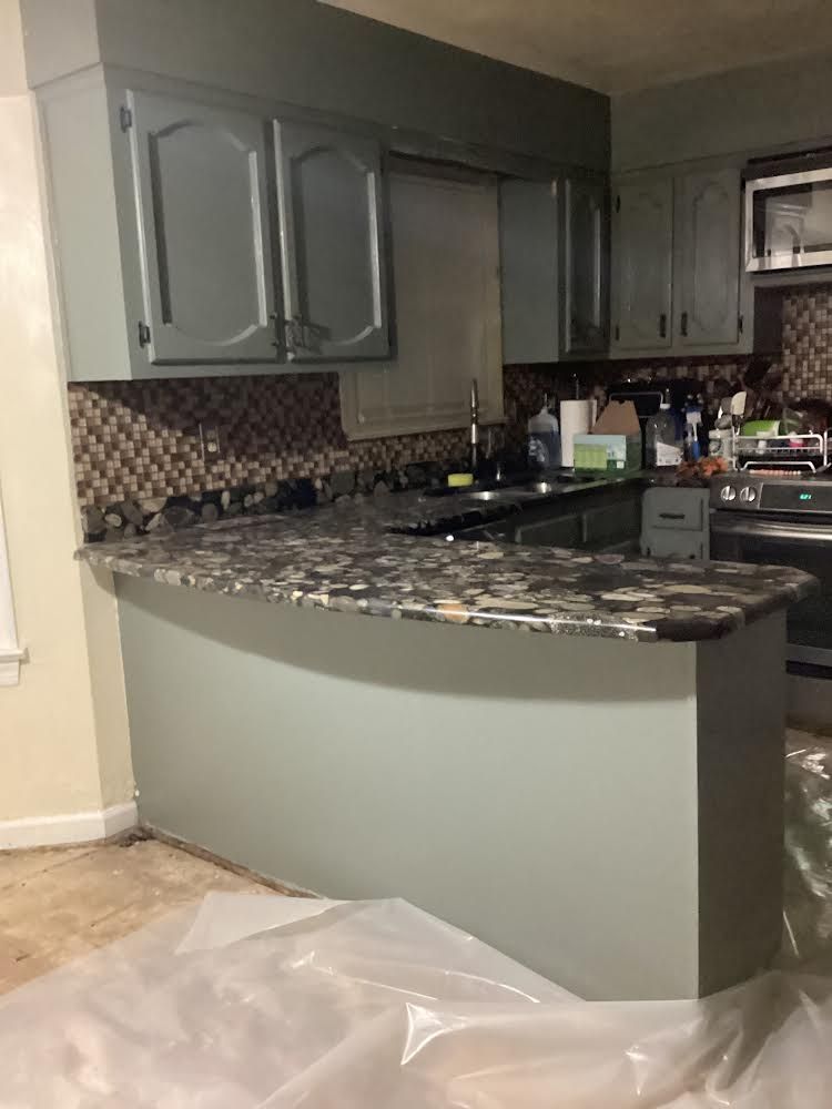 A kitchen under construction with a large island in the middle.