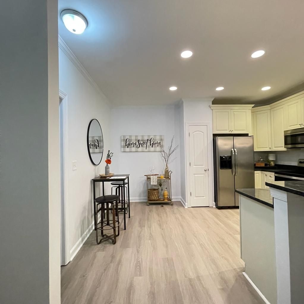 A kitchen under construction with white cabinets and wooden counter tops.