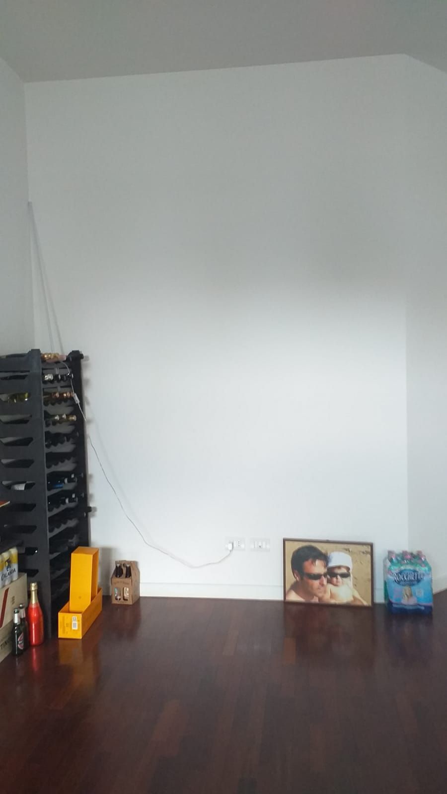 Pavimento in legno e parete bianca.