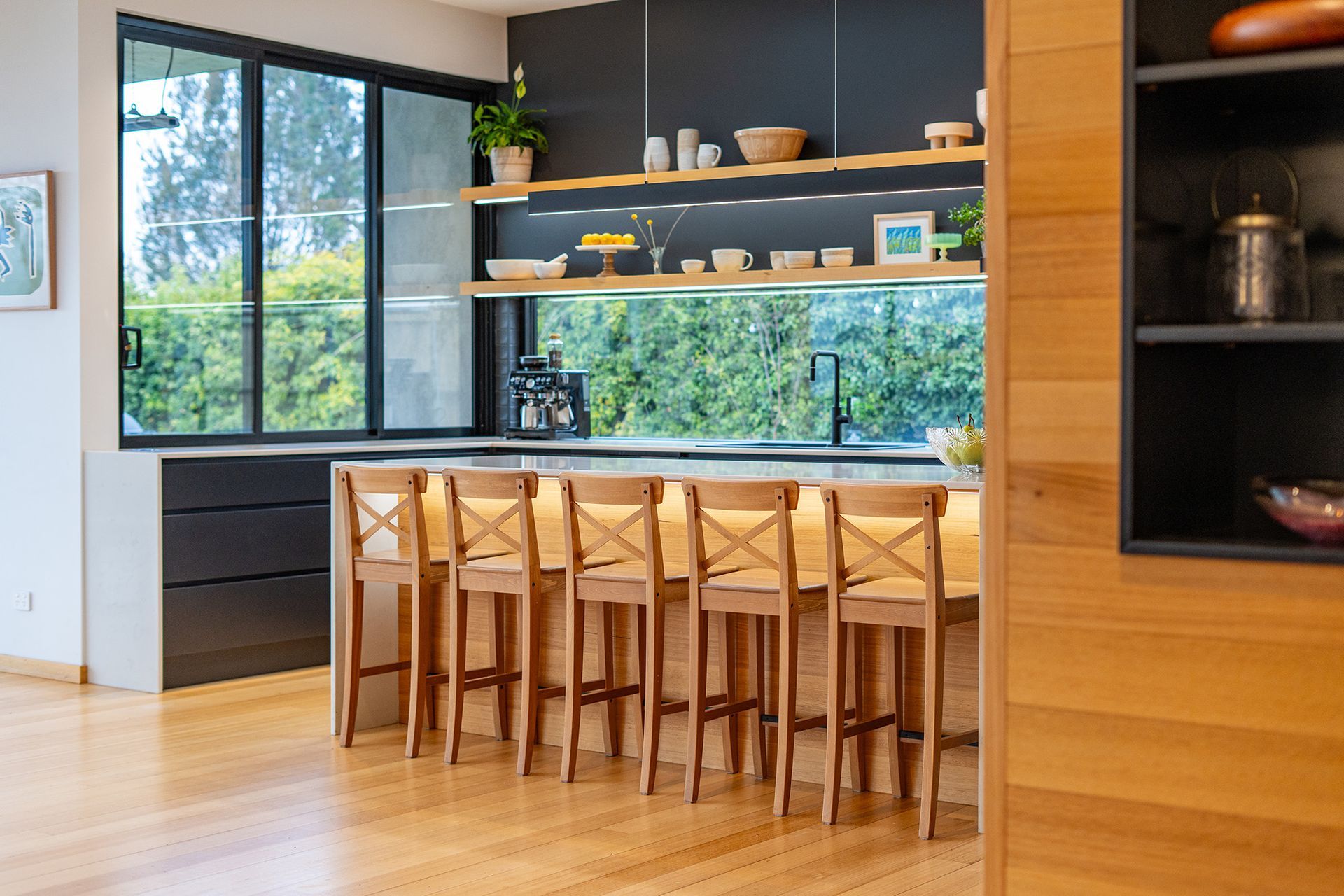 A kitchen with a large island and wooden stools