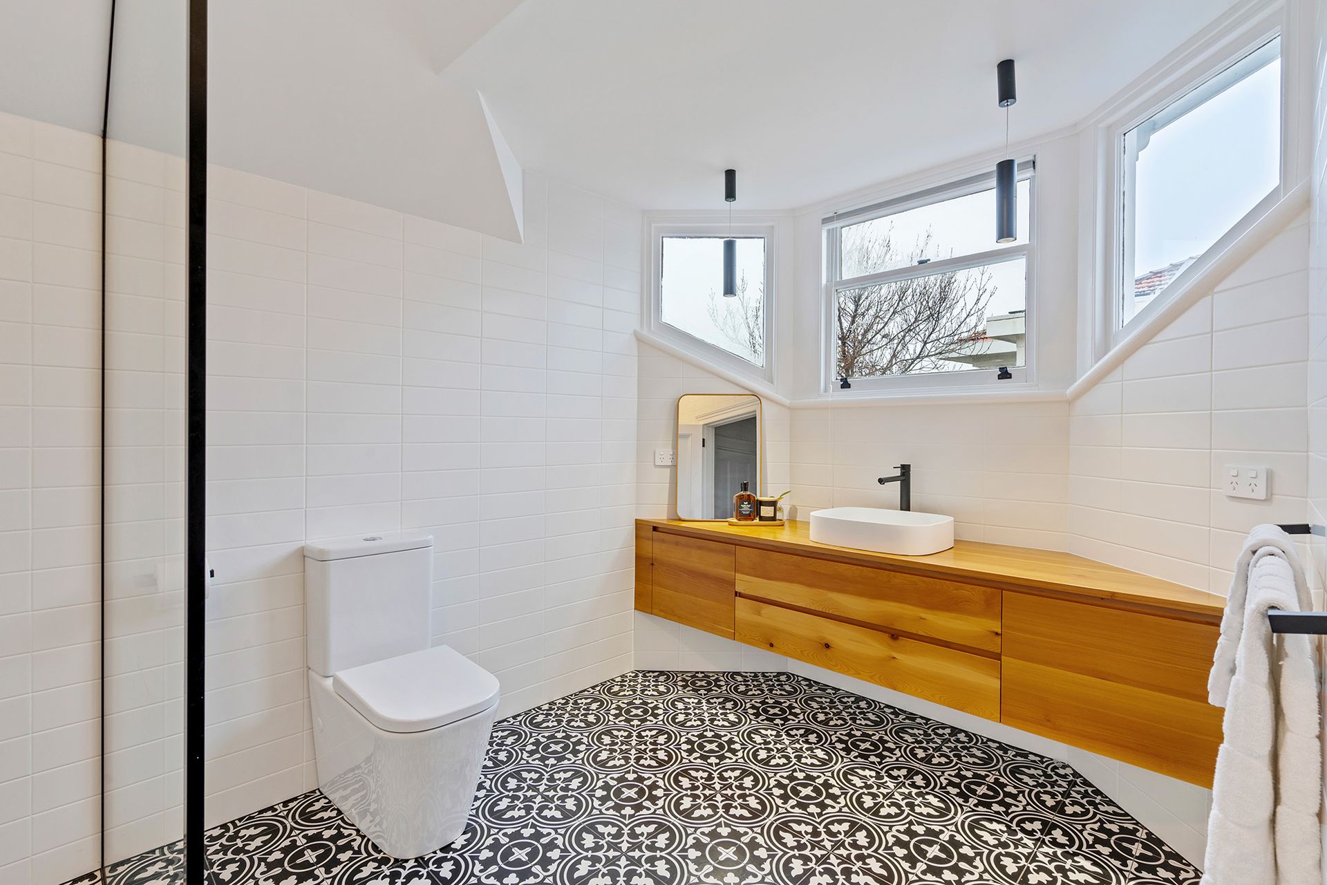 A bathroom with a toilet , sink , and mirror.