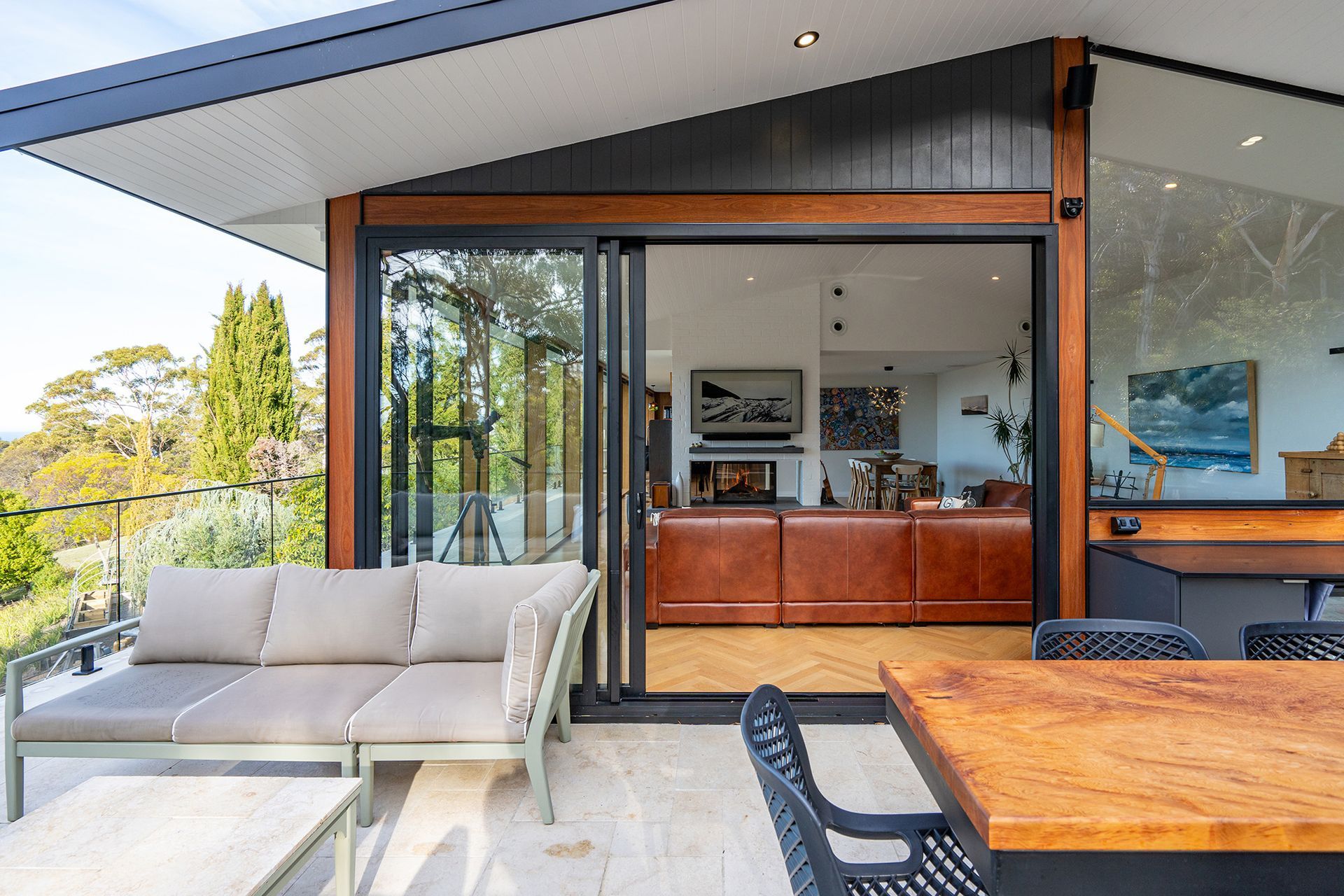 A living room with a couch , table , chairs and sliding glass doors.