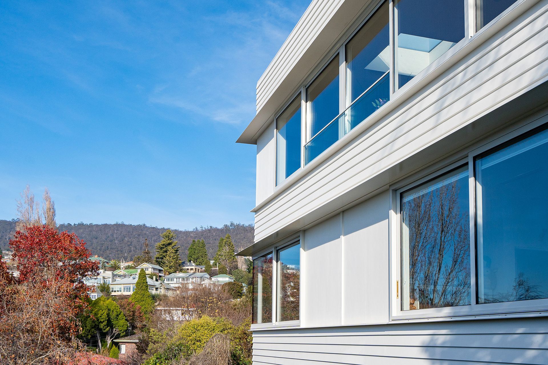 A white building with a lot of windows and trees in the background