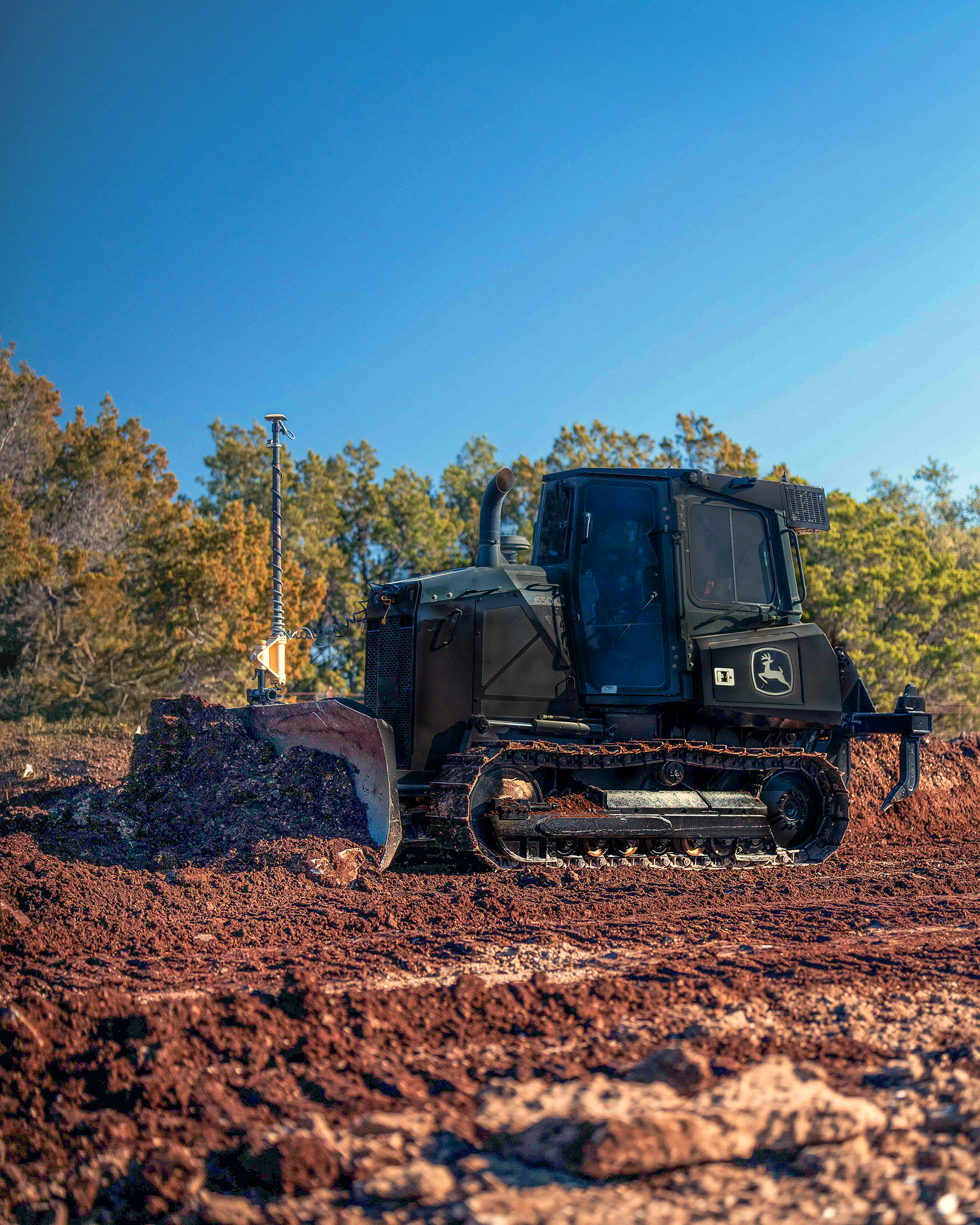 A bulldozer is driving through a muddy field.