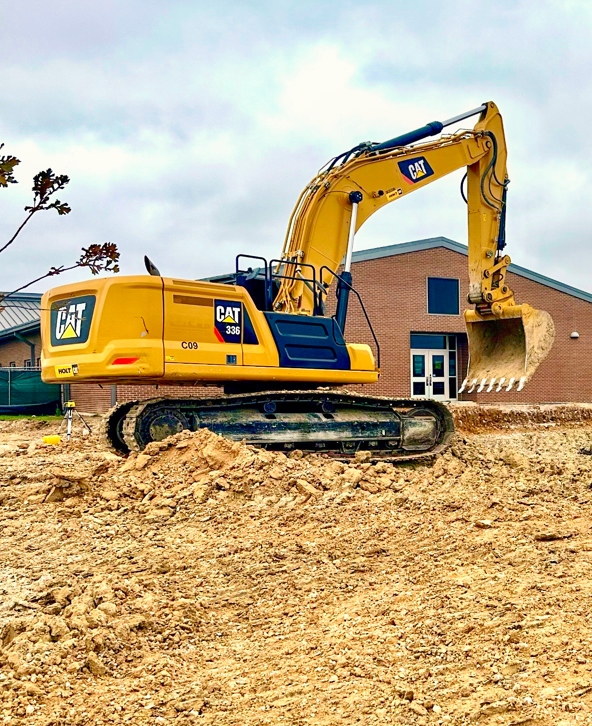 An aerial view of a dirt field with a building in the background.