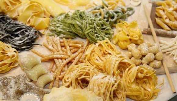 Varietà di pasta fresca artigianale come spaghetti e tagliatelle
