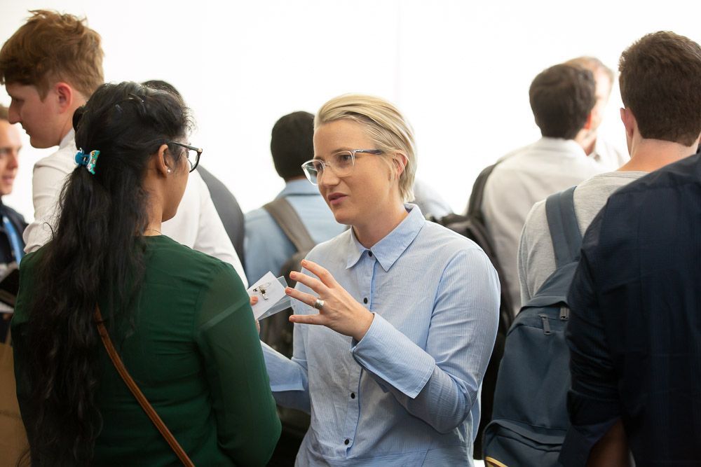 A woman is talking to another woman in a crowd of people.
