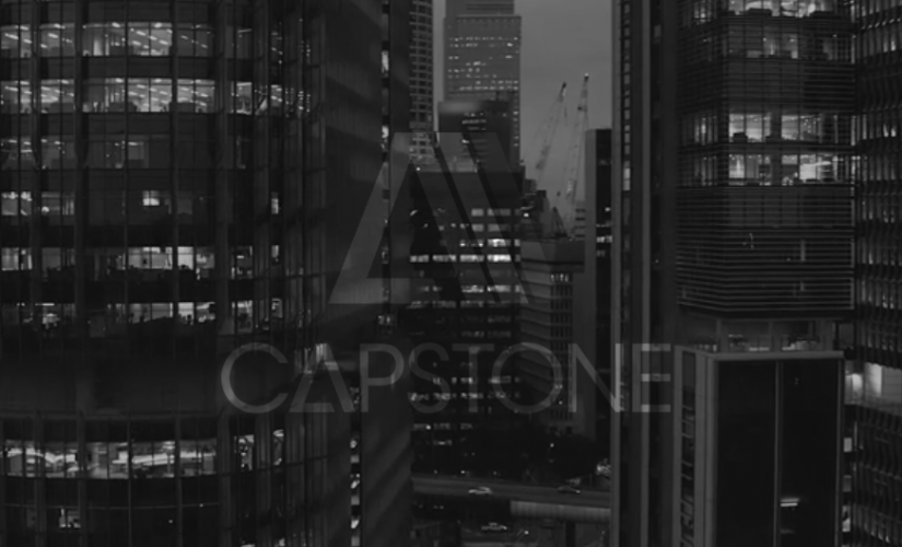 A black and white photo of a city at night with the caption capstone