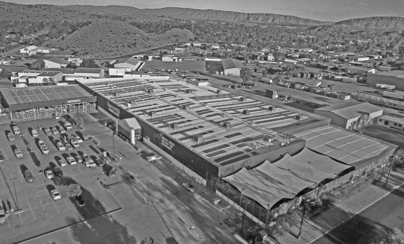 An aerial view of a large building with a lot of cars parked in front of it.
