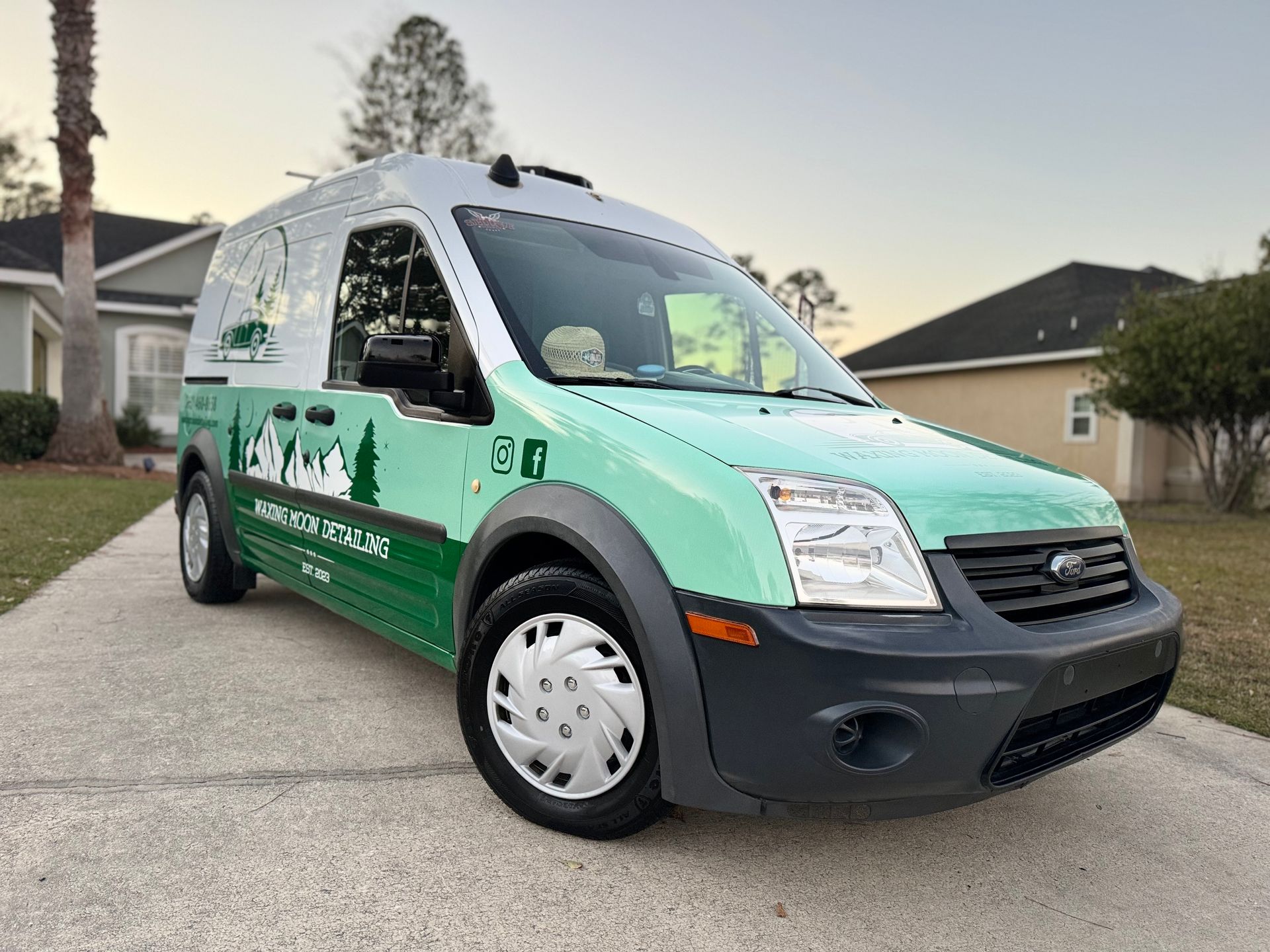 A gray car is parked next to a white car in a parking lot.