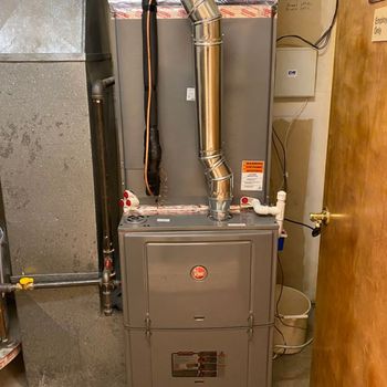 A furnace is sitting in a room next to a door.