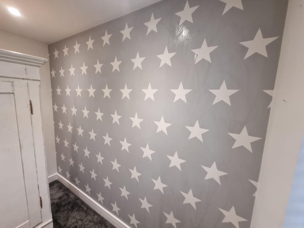 This is a picture of wallpaper with white stars and a grey background by Painters and decorators Leicester