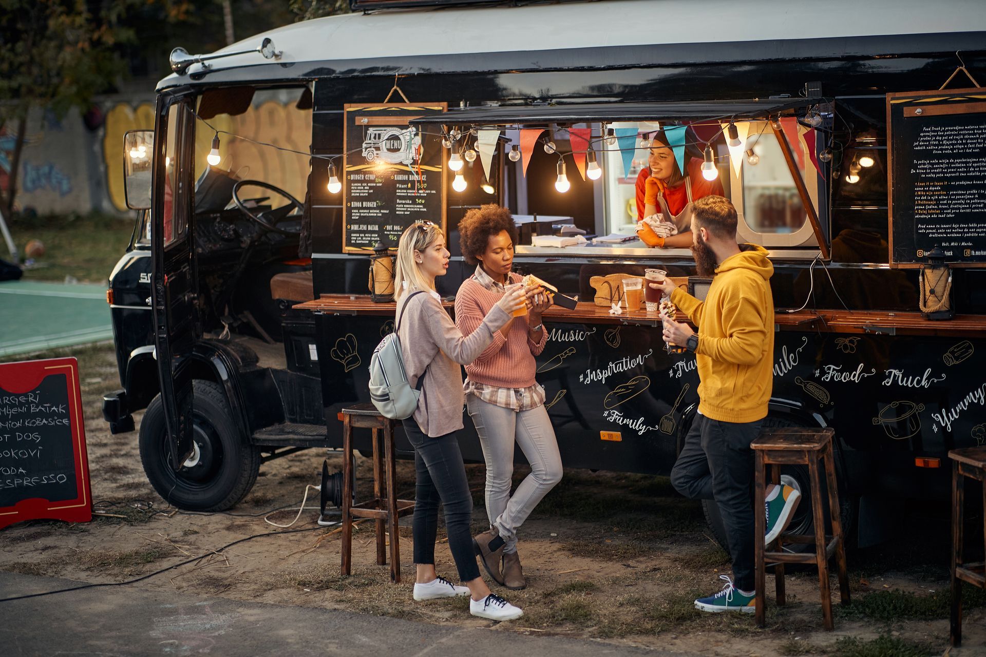 three people standing around a food truck