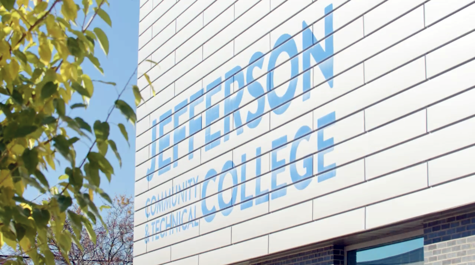 The exterior wall of a white, paneled building with 