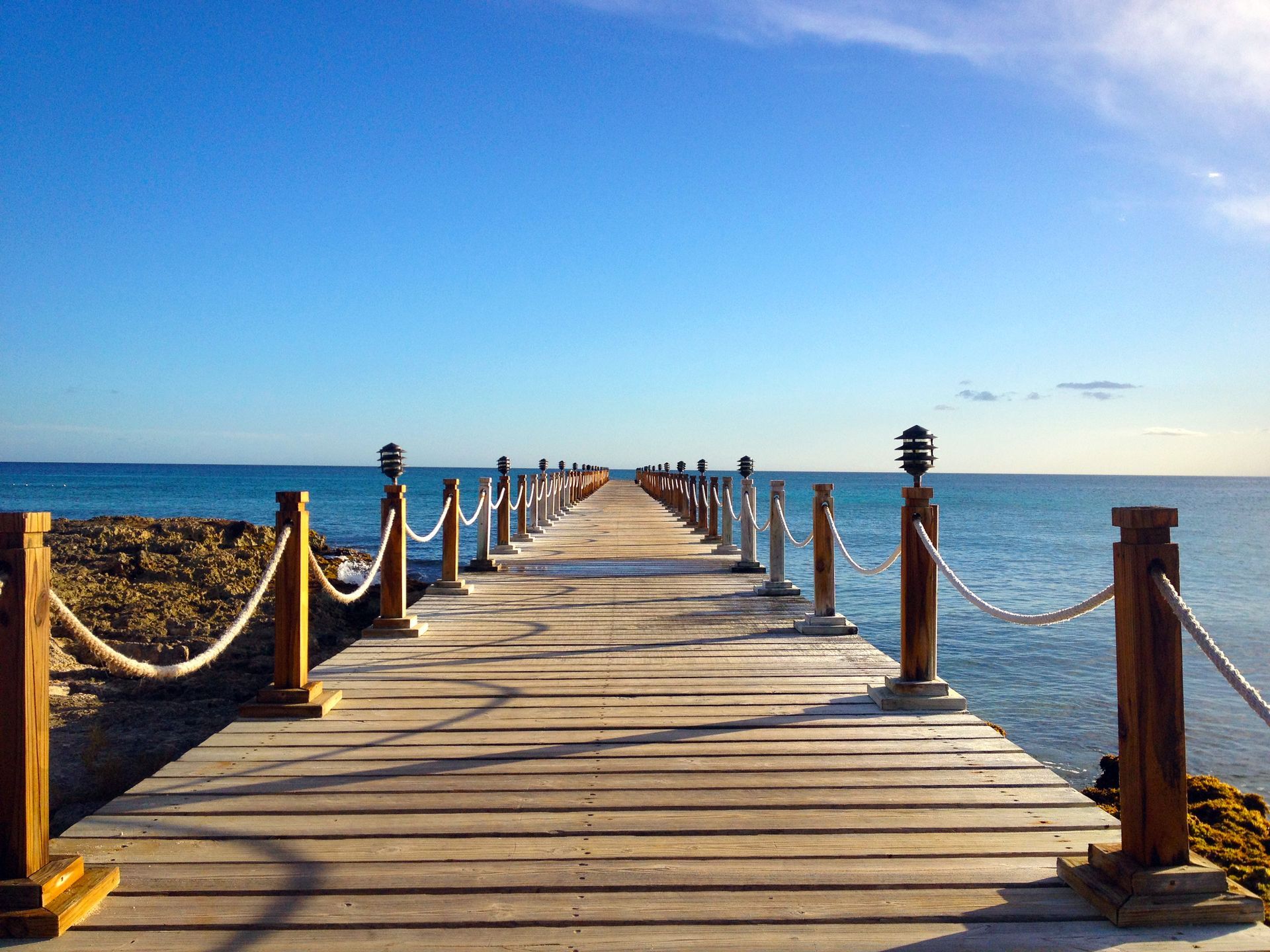 A long wooden pier leading into the ocean