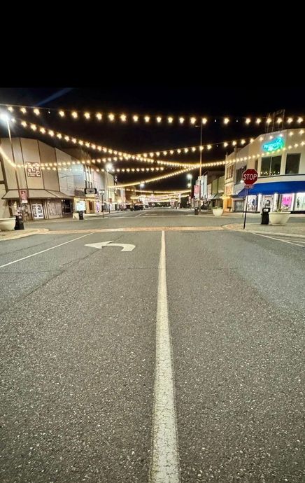 A street with a white line on the side of it at night.