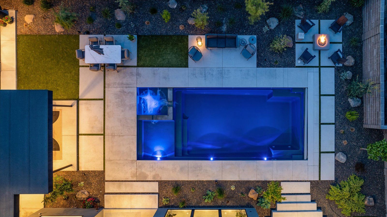 An aerial view of a large swimming pool in the backyard of a house.