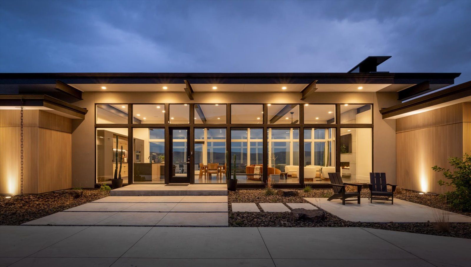 A modern house with a swimming pool and a fire pit in front of it.