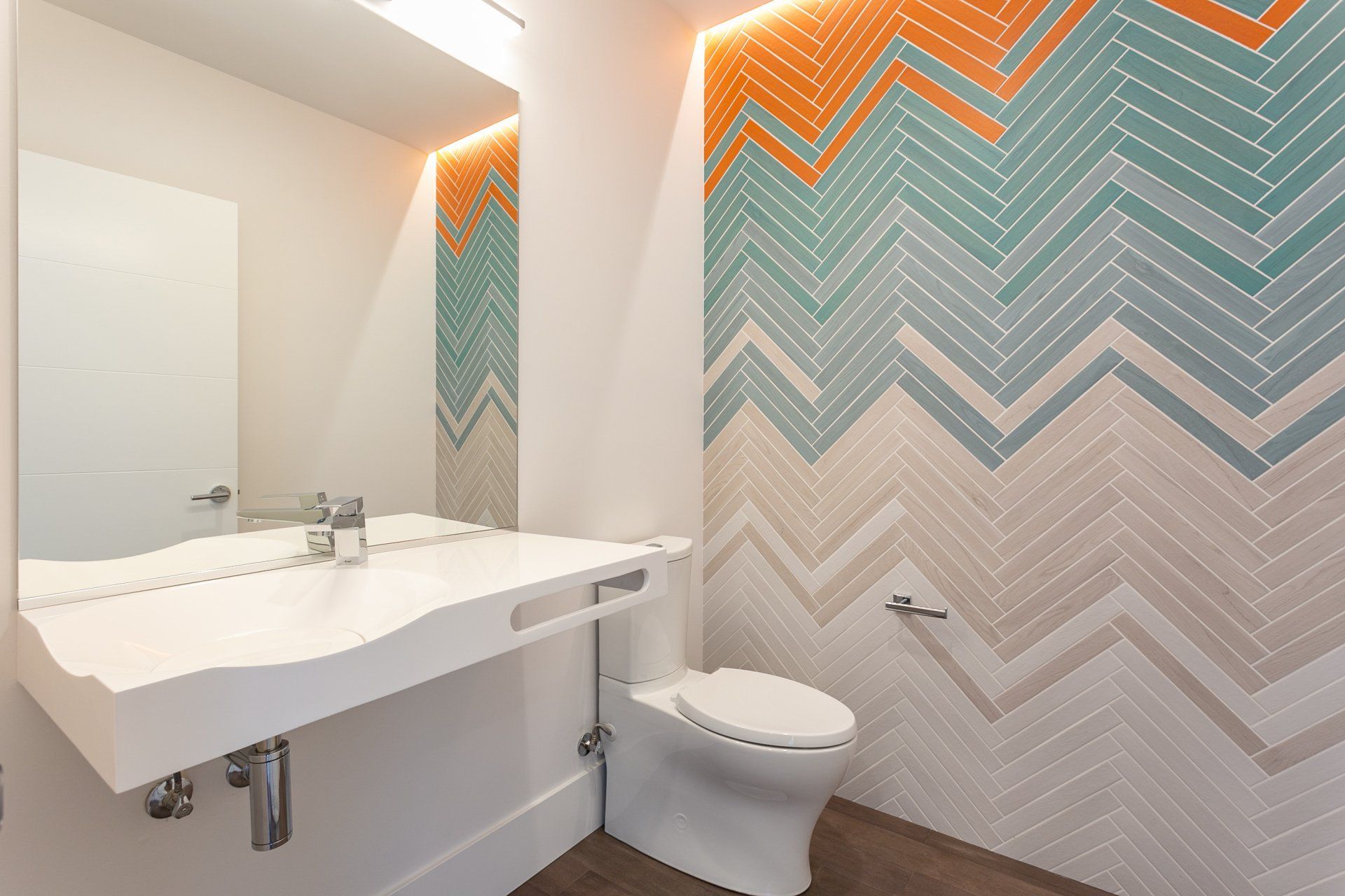 A bathroom with a toilet , sink and mirror.