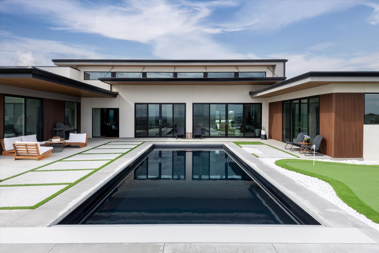 A large house with a large swimming pool in front of it.