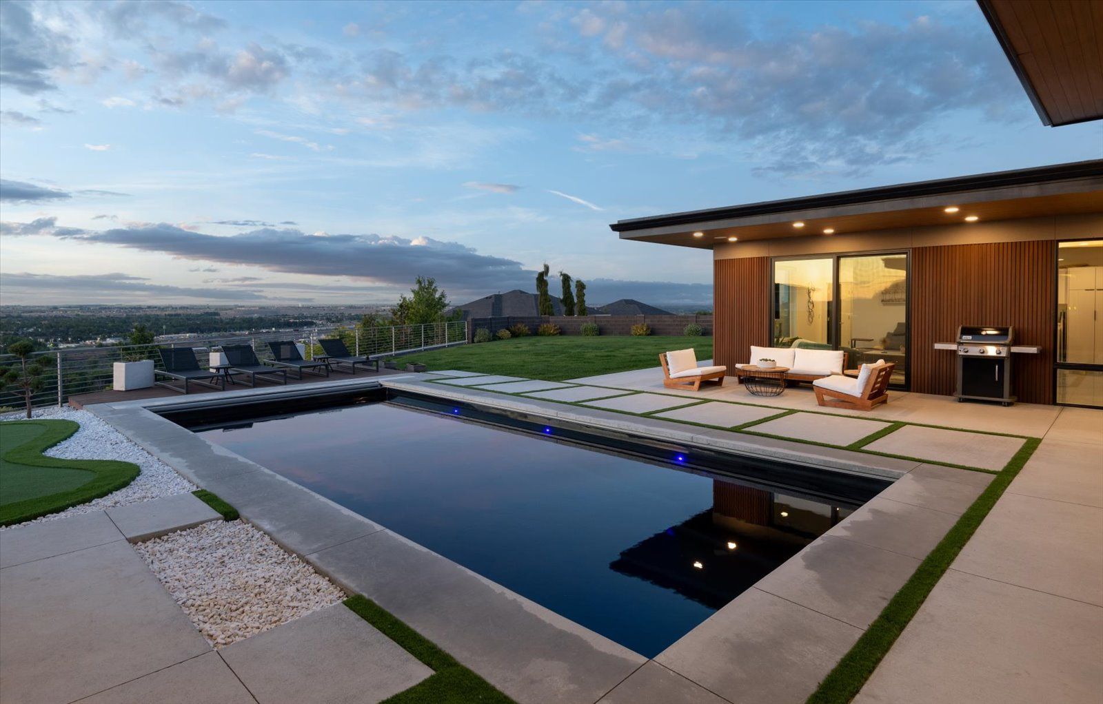 There is a large swimming pool in the backyard of a house.