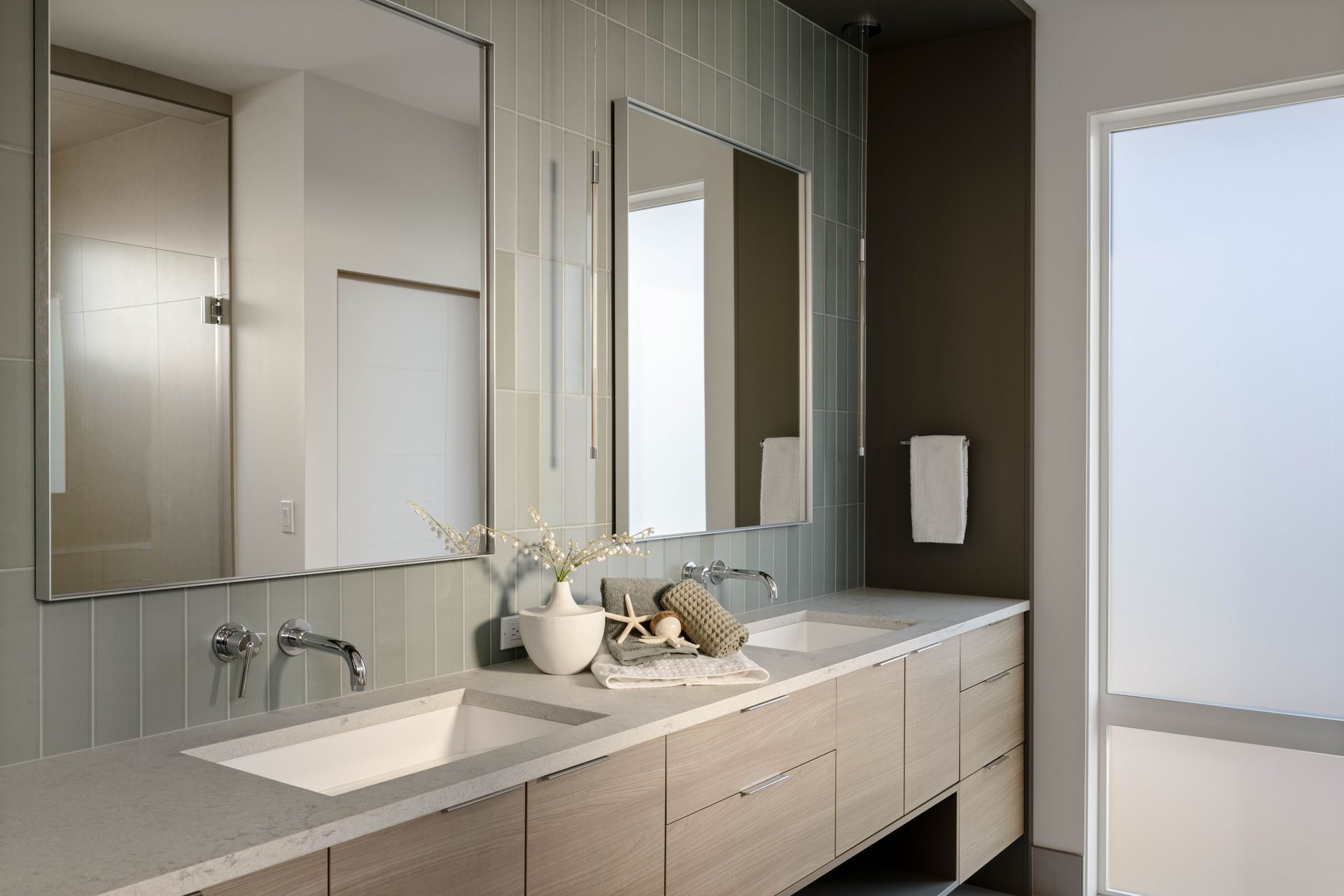 Modern bathroom with double sinks, mirrors, and muted gray and beige tones.