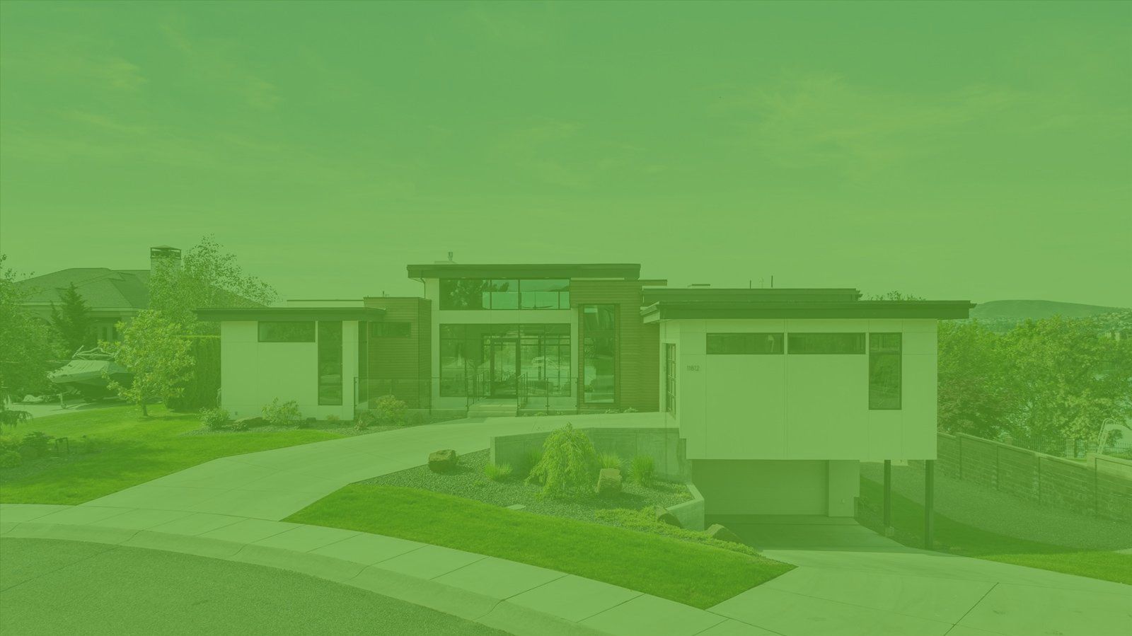 A modern house is sitting on top of a lush green hillside.