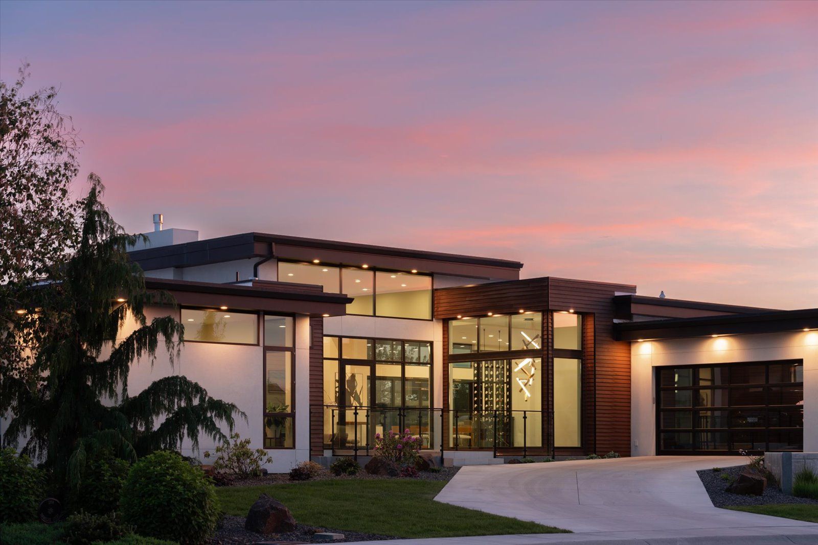 A modern house with a lot of windows and a driveway