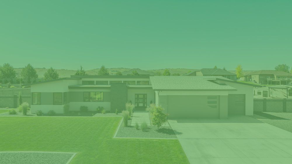An aerial view of a house with a lush green lawn.