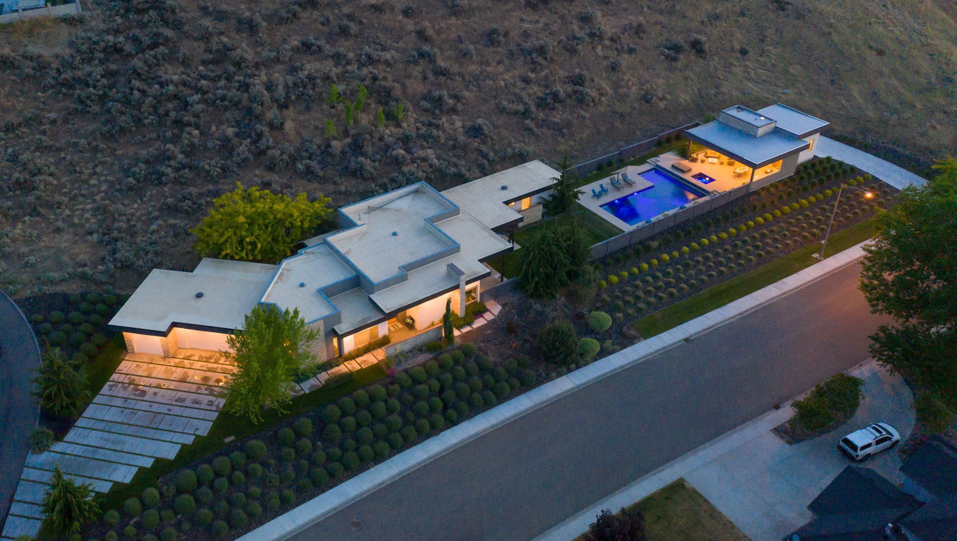 An aerial view of a house on a hill with a pool.