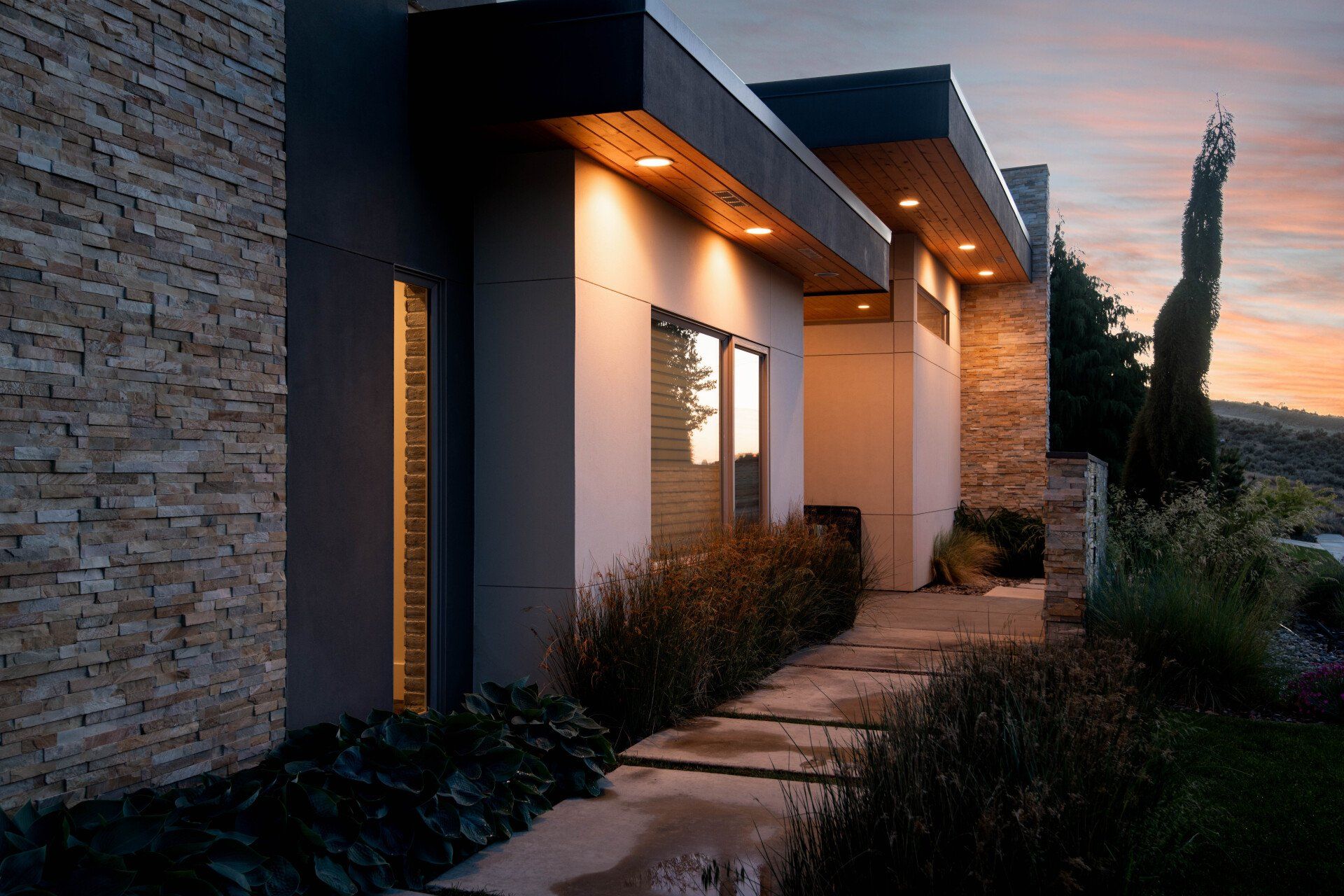 A house with a stone wall and a walkway leading to it