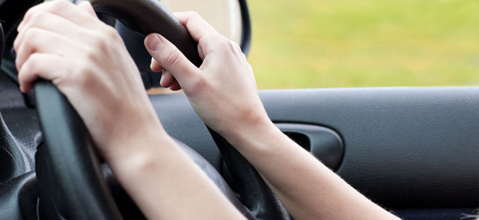 Person holding steering wheel