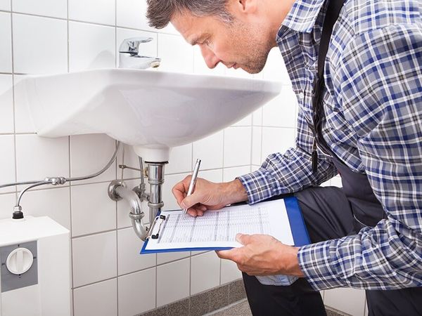 Plumber Checks the Bathroom Sink — Plumbing Maintenance in Brisbane, QLD