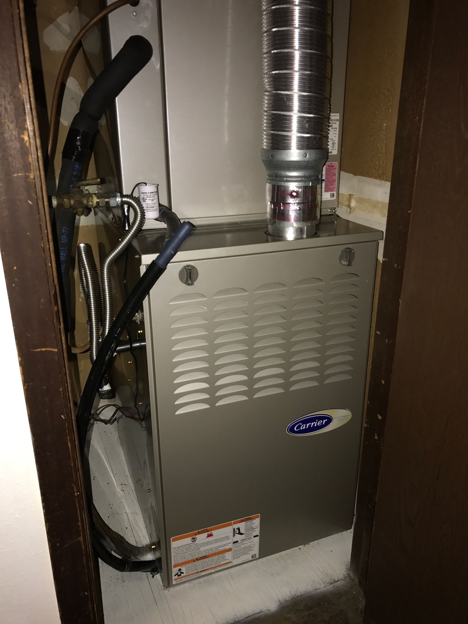 An air conditioner is sitting in a closet next to a door.