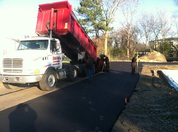 Asphalt Road Repair Services  — Road While Men Are Paving  Asphalt in Saginaw, MI