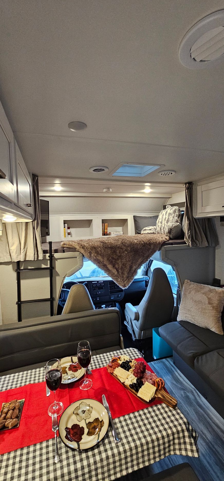 A living room in a rv with a table and plates on it.