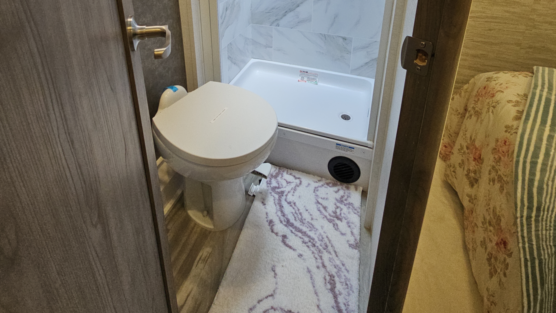 A bathroom with a toilet , sink and mirror.