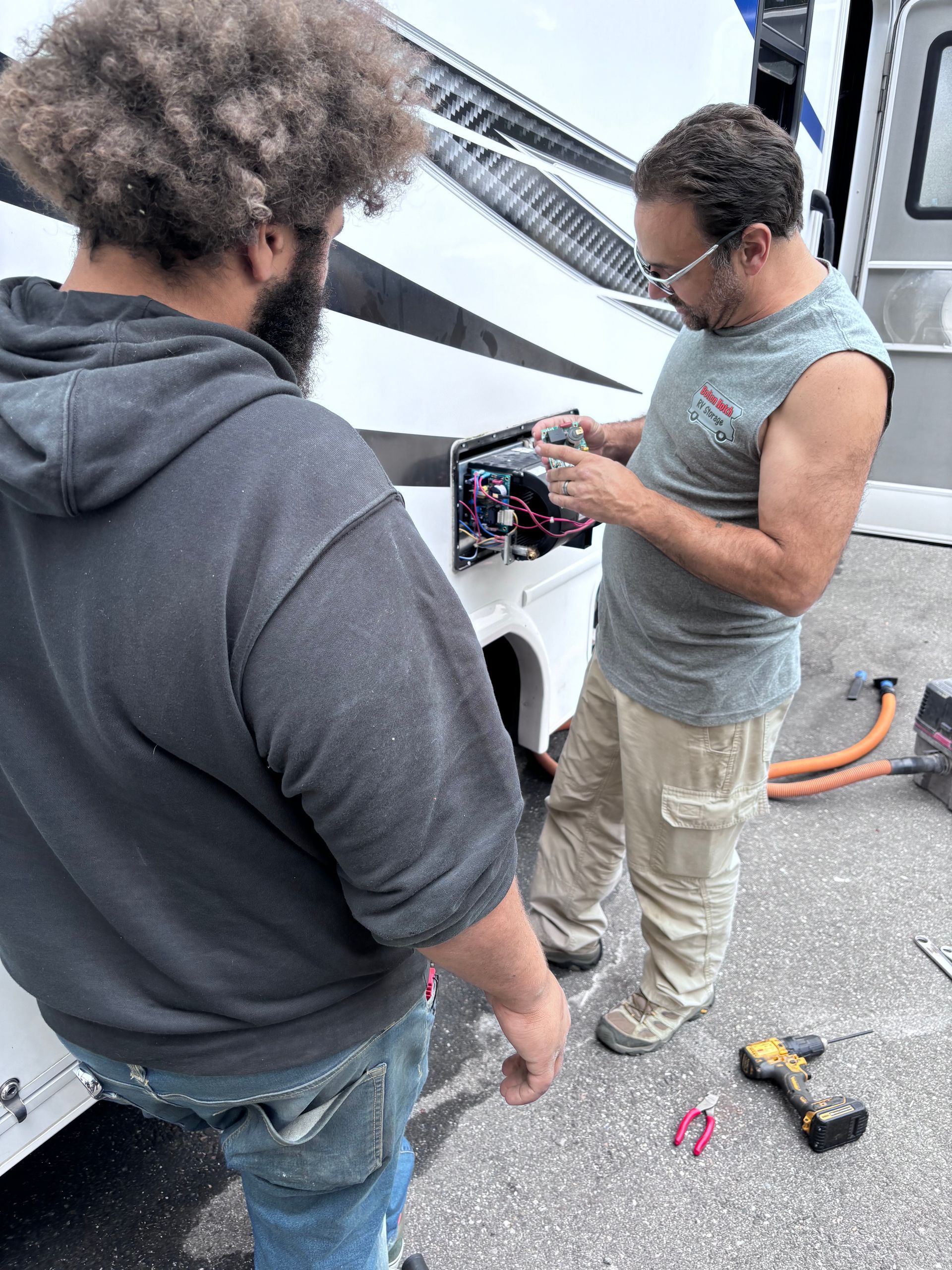 A group of men are working on a large piece of metal in a garage.