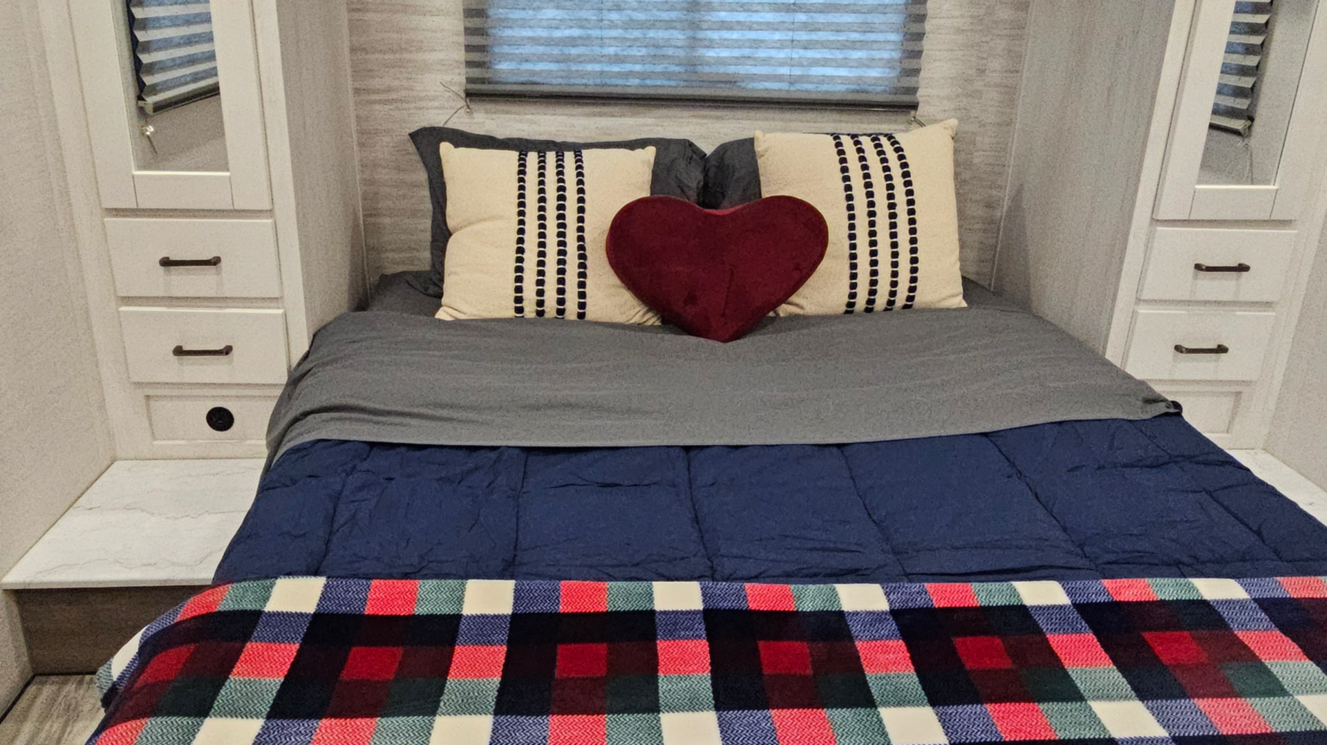 There is a bed in the middle of the room in a rv.