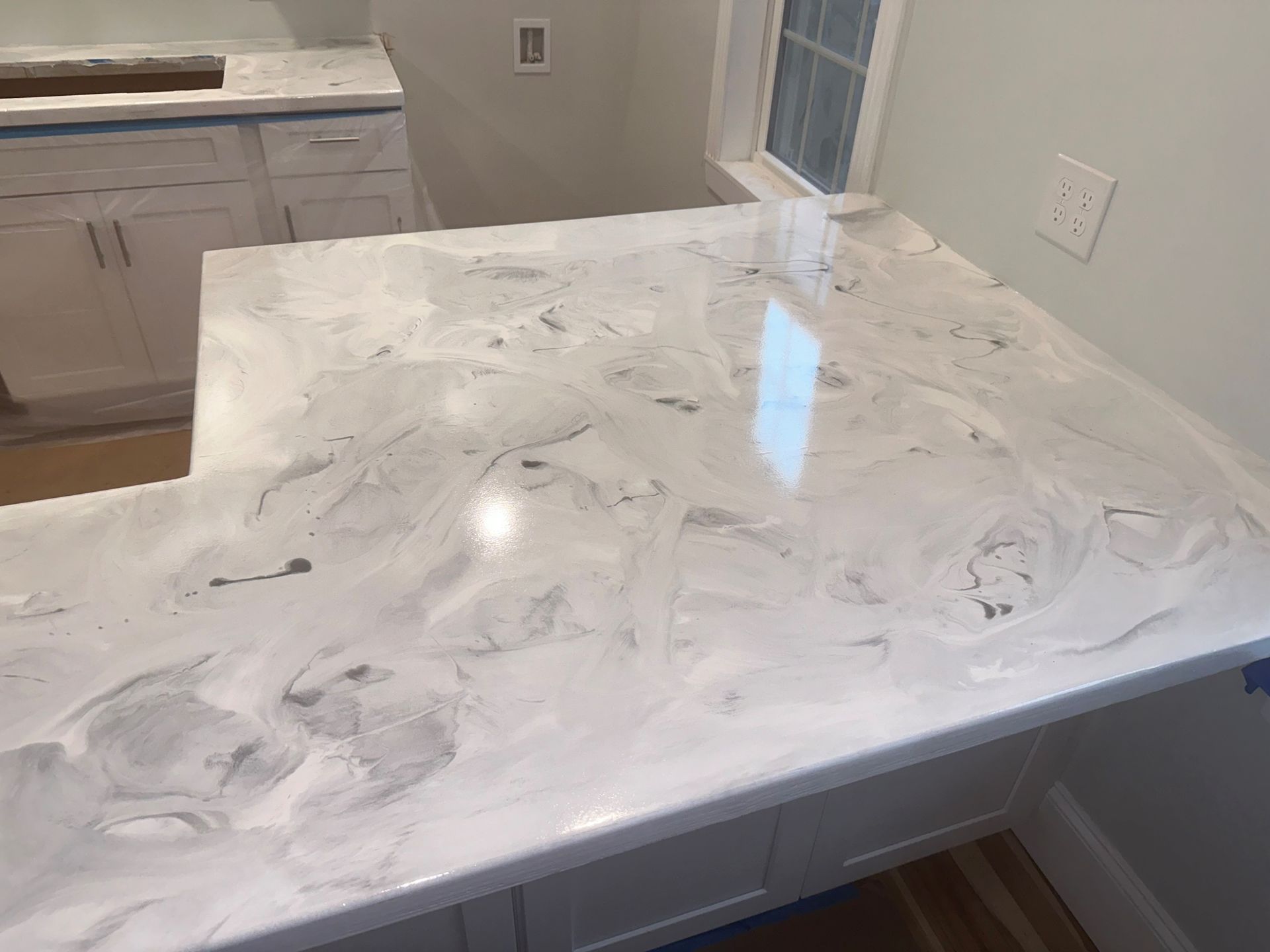 A kitchen counter with a white counter top and white cabinets.