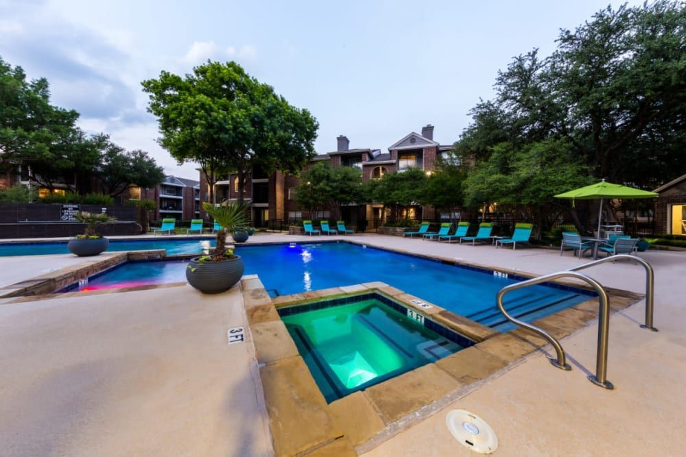 A large swimming pool with a hot tub in the middle at Marquis at Legacy in Plano, TX.