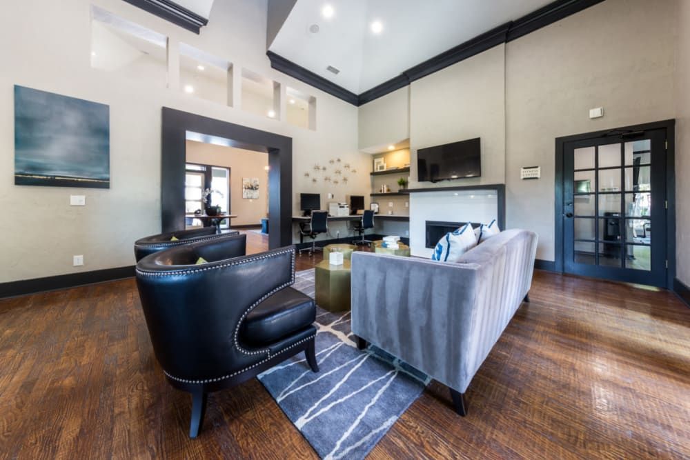 Clubhouse resident area with a couch, chairs, and a fireplace at Marquis at Legacy in Plano, TX.