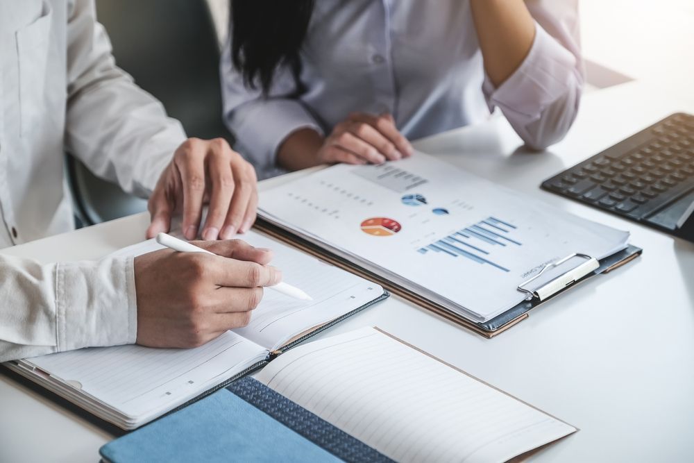 Two Professionals Reviewing Financial Charts — Mitchell Playford & Radburn Solicitors in Grafton, NSW