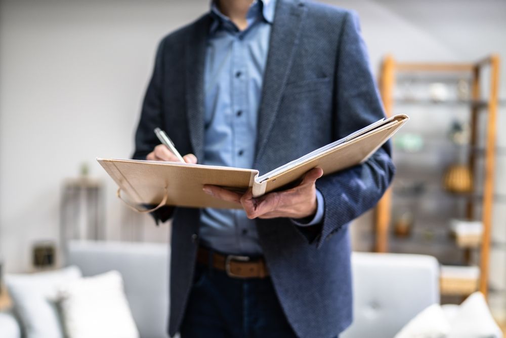 A Person Holds a Spiral-Bound Notebook and Pen — Mitchell Playford & Radburn Solicitors in Grafton, NSW