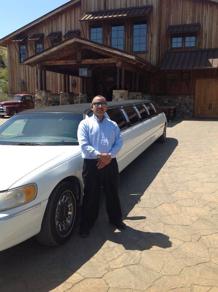 A man is standing in front of a white limousine