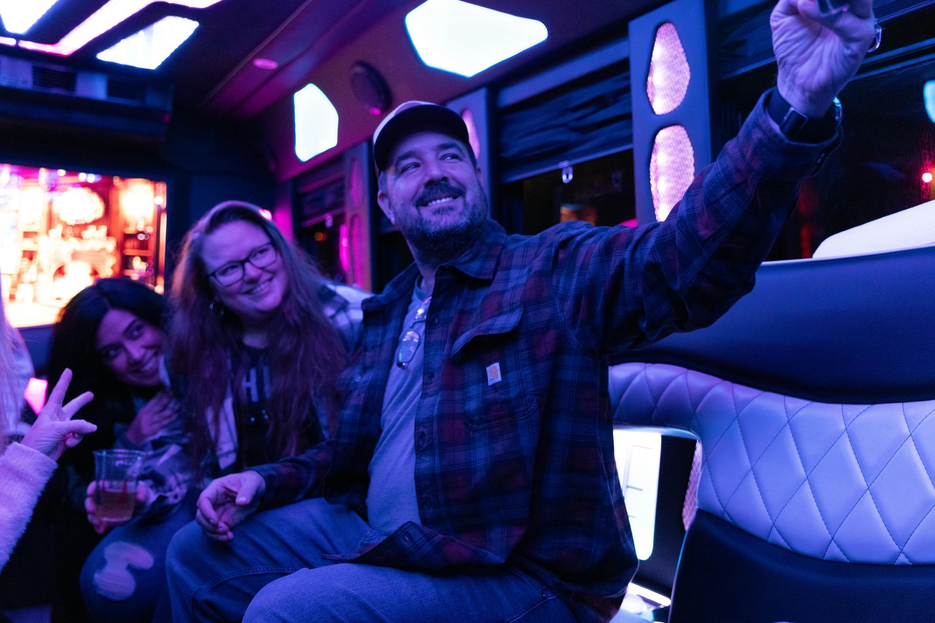 A group of people are sitting on a bus taking a selfie.