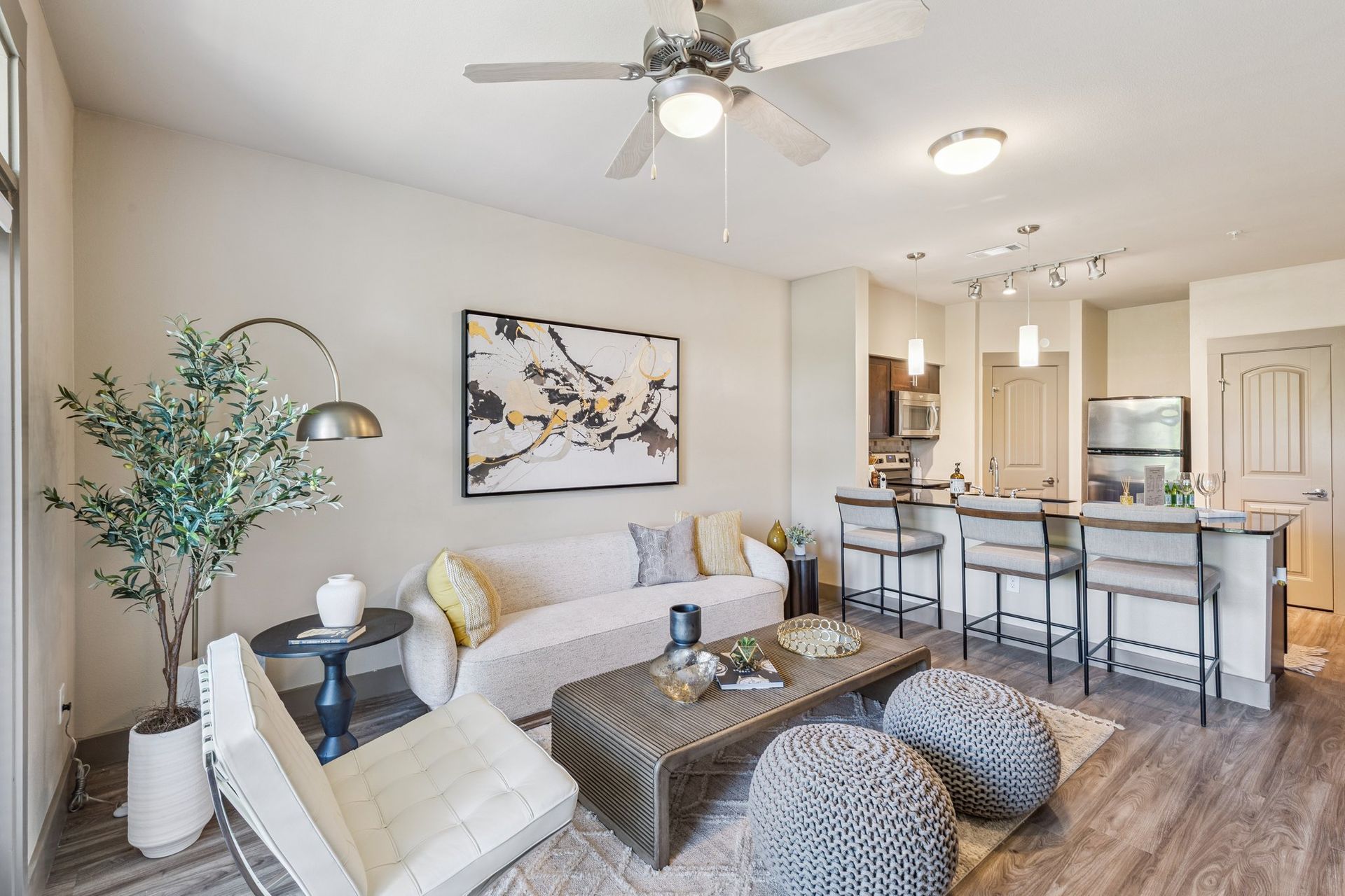 Living room with a sofa, chairs, coffee table, and open kitchen.