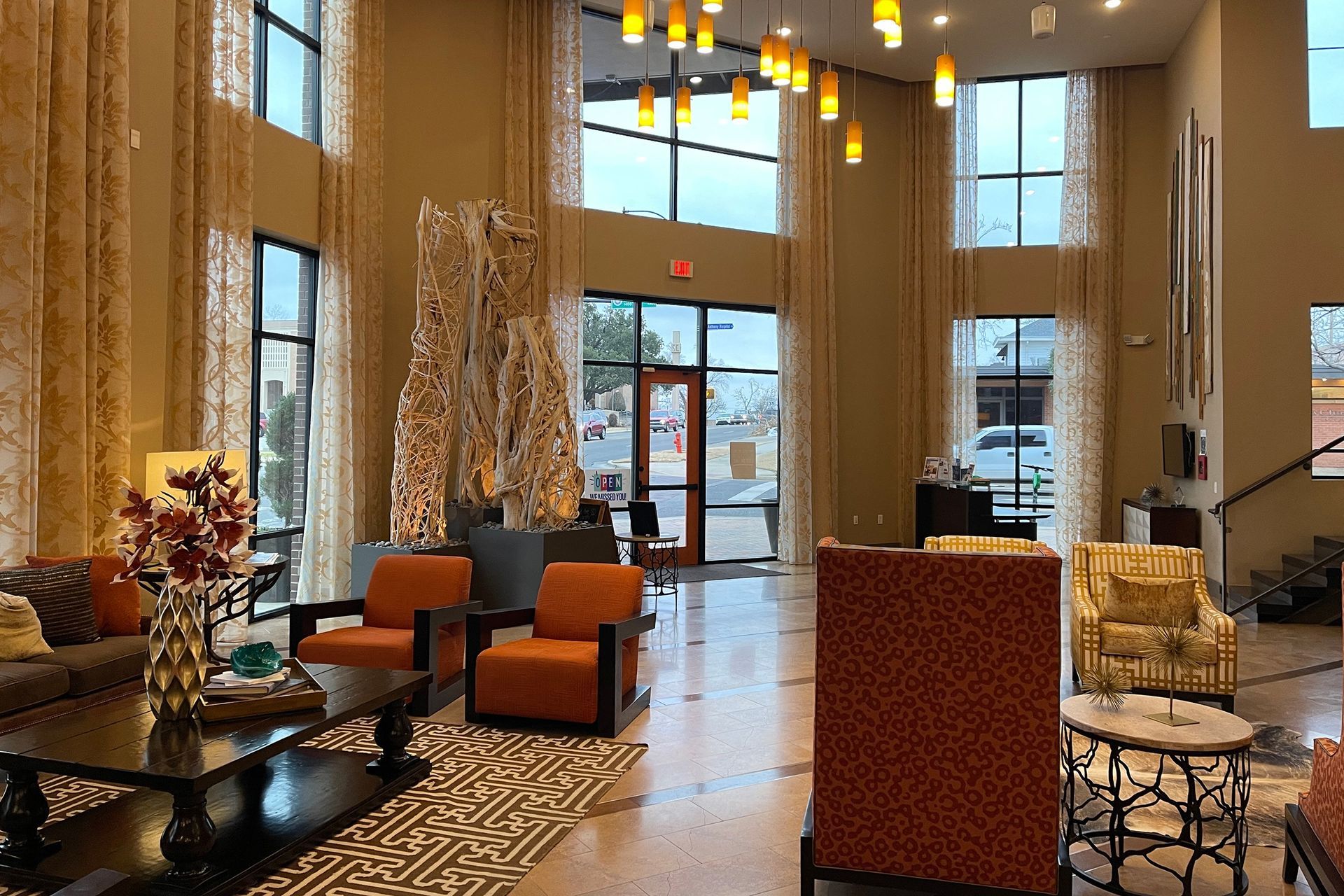 There are many chairs and tables in the lobby of the apartment community.