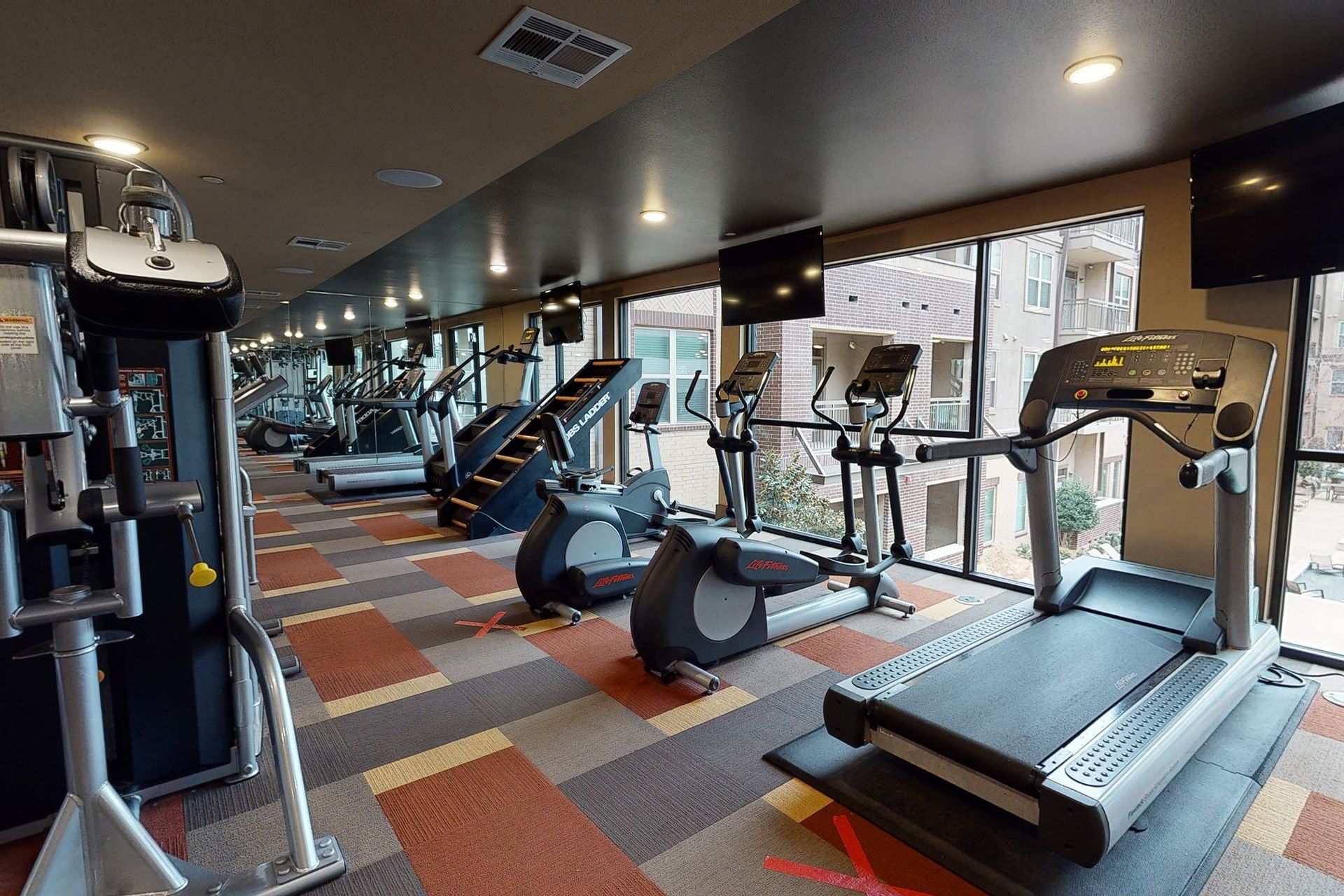 A gym with a lot of treadmills and exercise equipment.