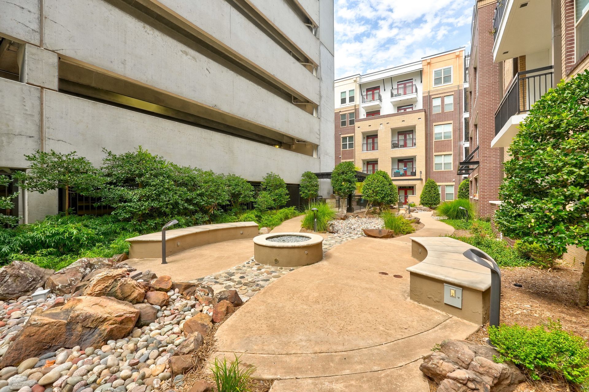 A courtyard with a fire pit in the middle of it.